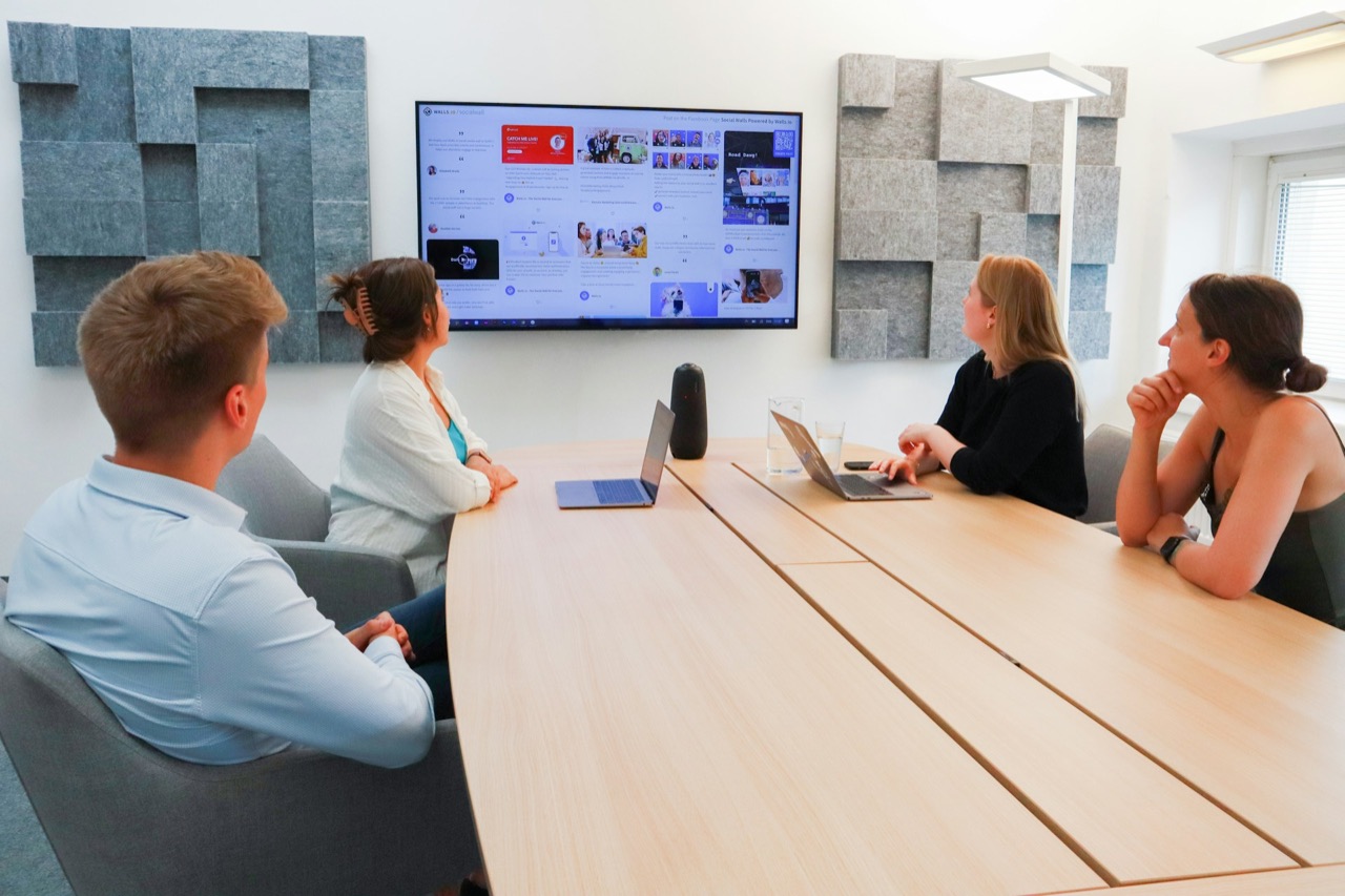 Team meeting in a commissioned video conferencing room with a display and acoustic wall panels