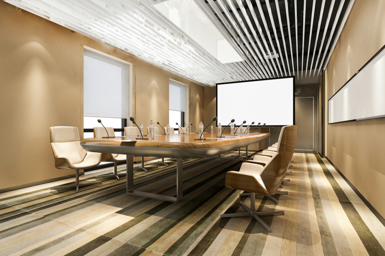 Boardroom with a long table and presentation screen set up for a meeting